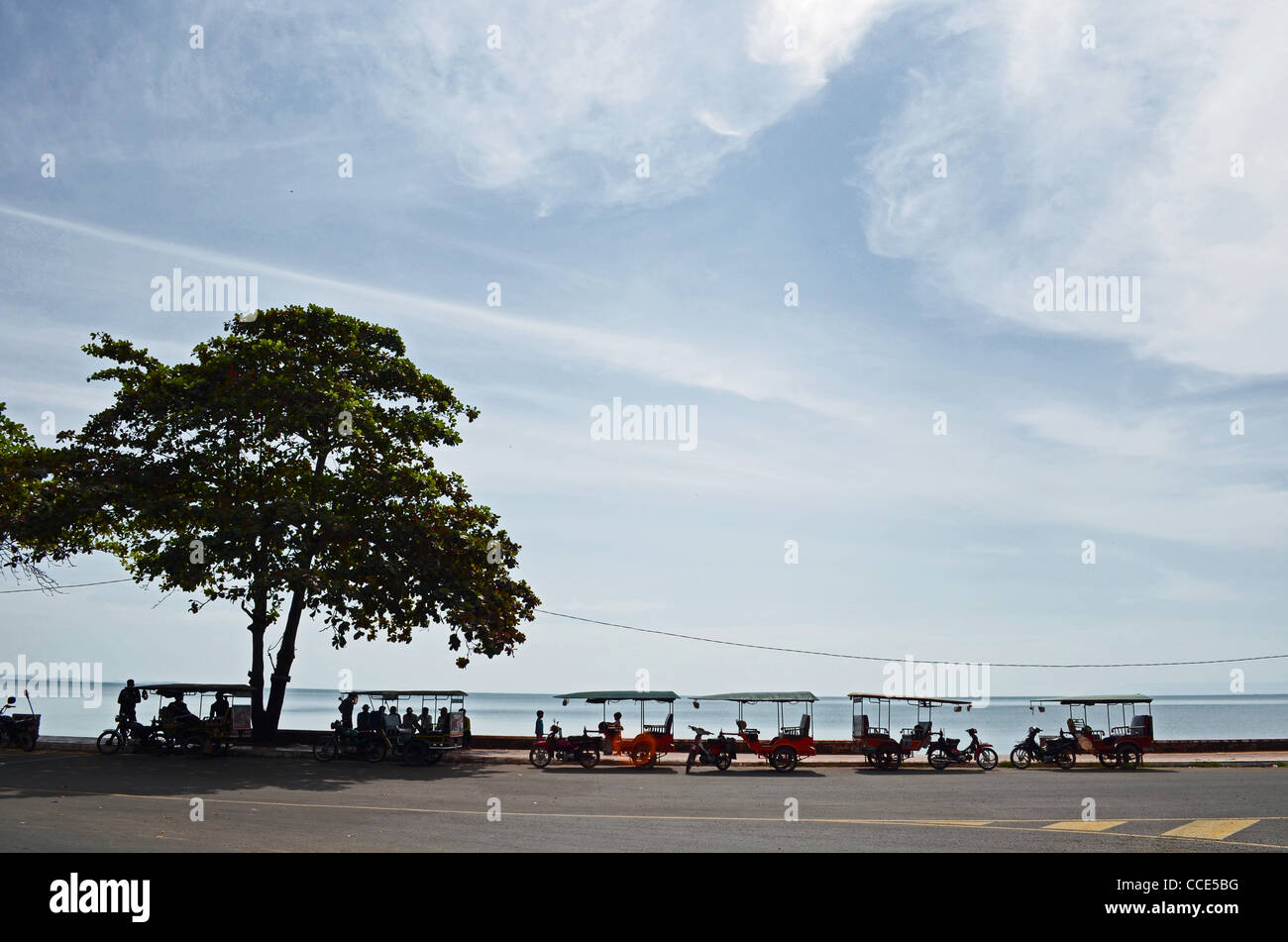 Tuktuks attendre les passagers en première ligne de la plage de Kep, Cambodge Banque D'Images