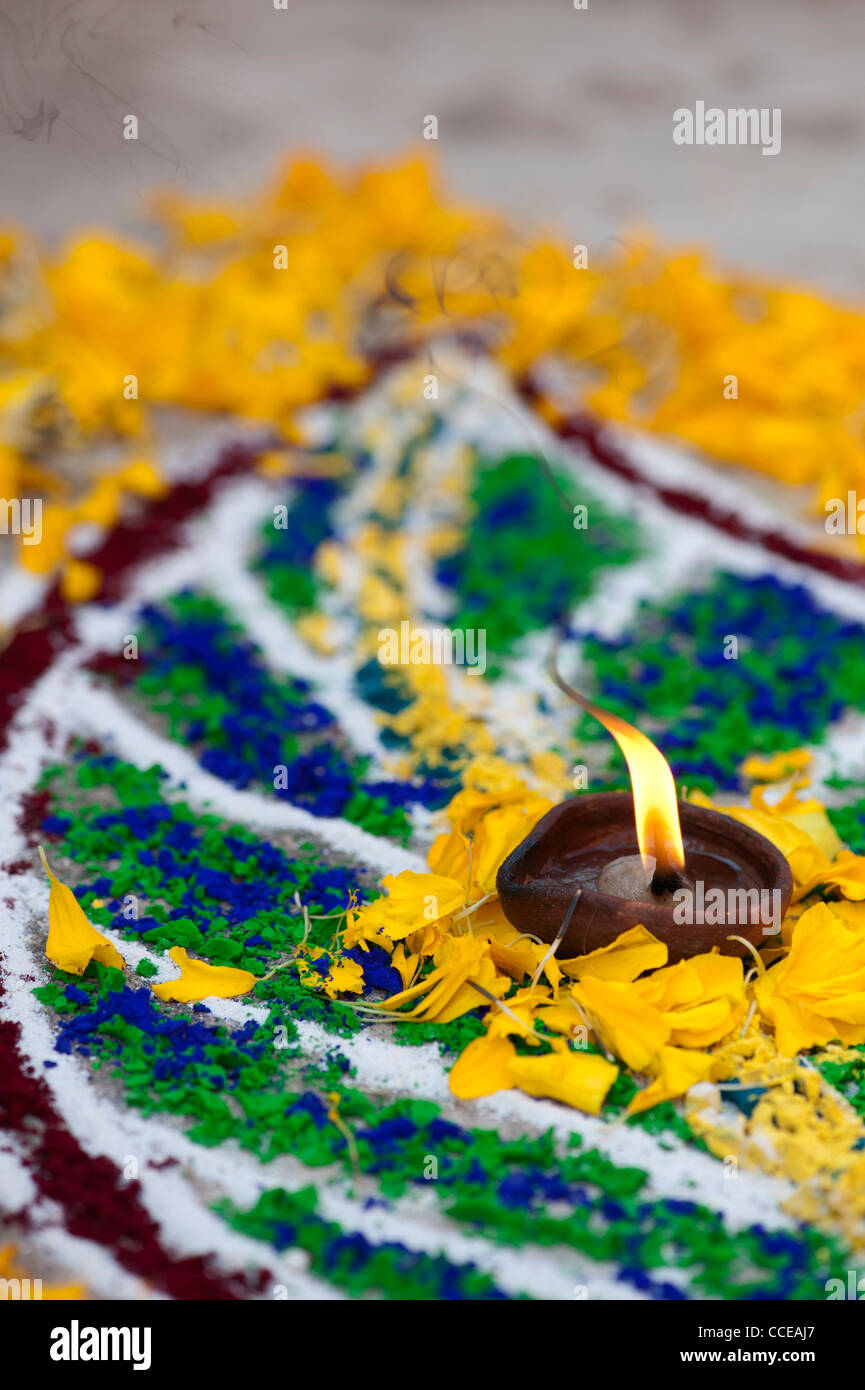 Rangoli sankranthi poudre colorée festival lames, avec pétales de fleurs et une lampe à huile. L'Inde Banque D'Images