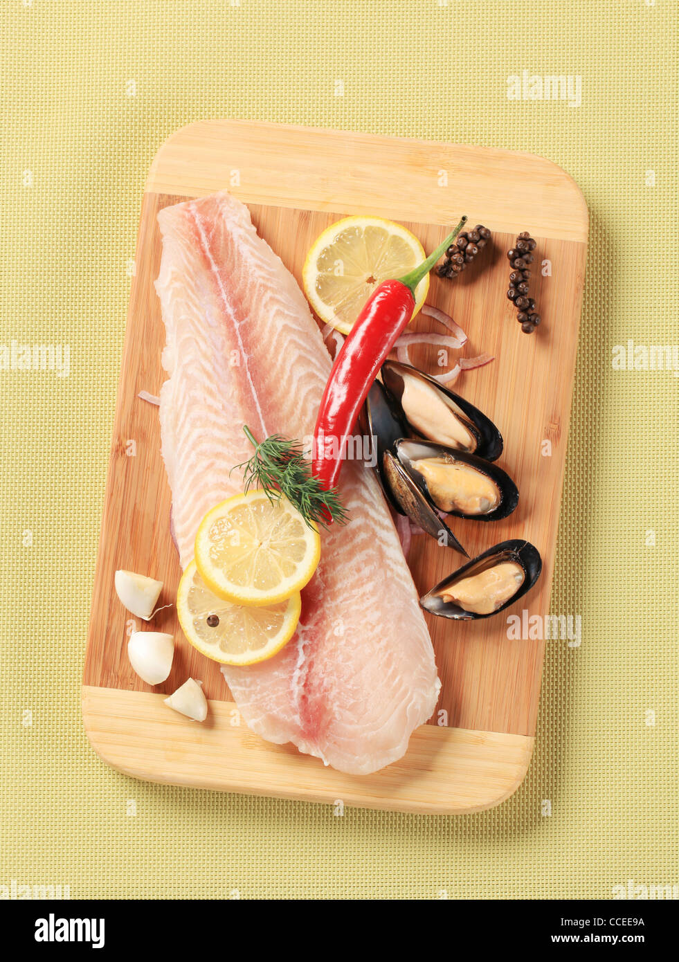 Filet de poisson frais et les moules sur une planche à découper Banque D'Images