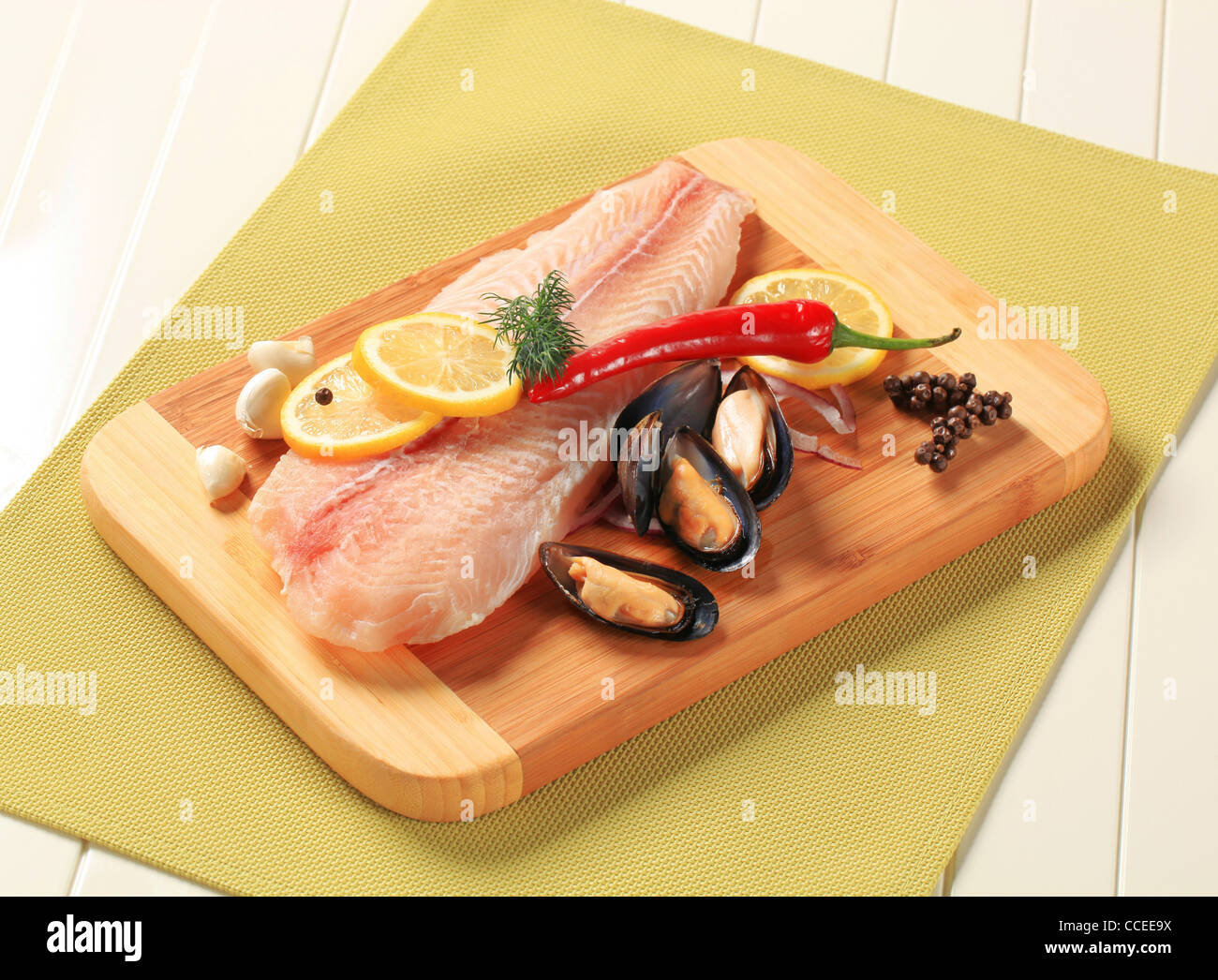 Filet de poisson frais et les moules sur une planche à découper Banque D'Images