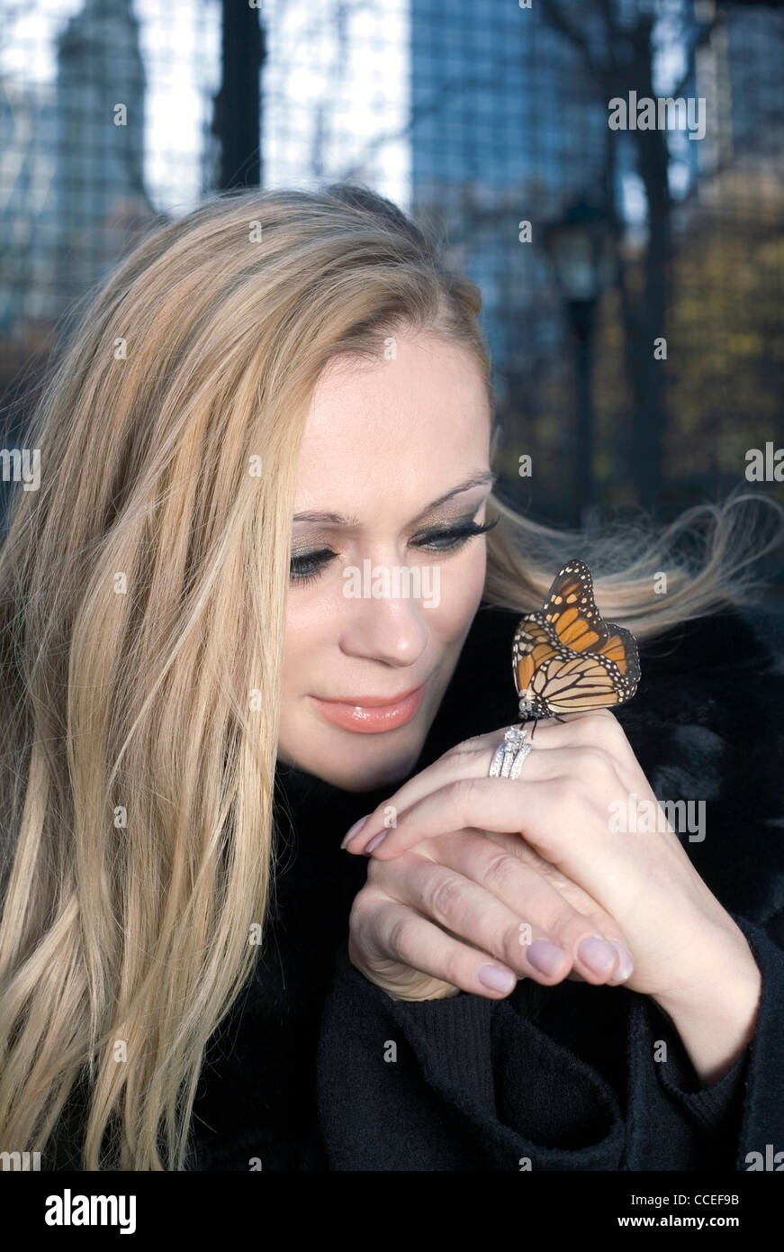 Une femme de race blanche à l'extérieur tenant un papillon insecte. Banque D'Images