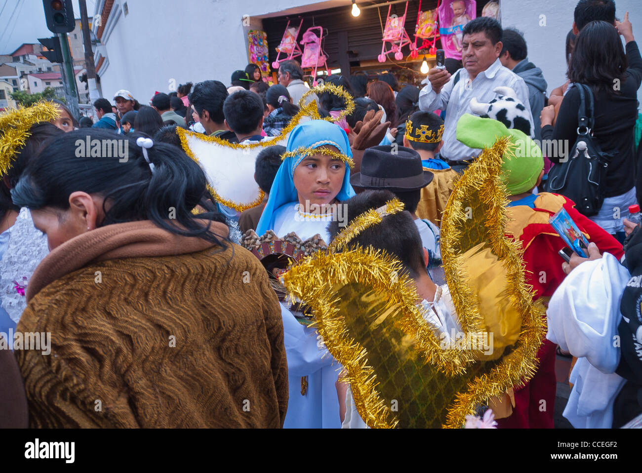 Un vieux de 12 à 13 ans fille hispanique habillé comme la Vierge Marie promenades dans la foule dans le Children's Parade de Noël, Quito, Équateur. Banque D'Images