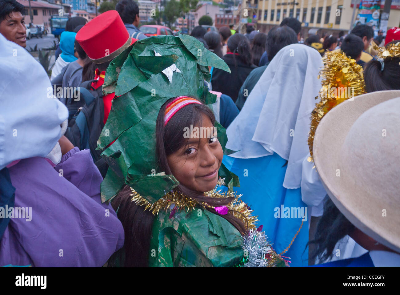 Un vieux de 12 à 13 ans fille hispanique vêtu d'un costume d'arbre vert promenades dans le Children's Parade de Noël, Quito, Équateur. Banque D'Images