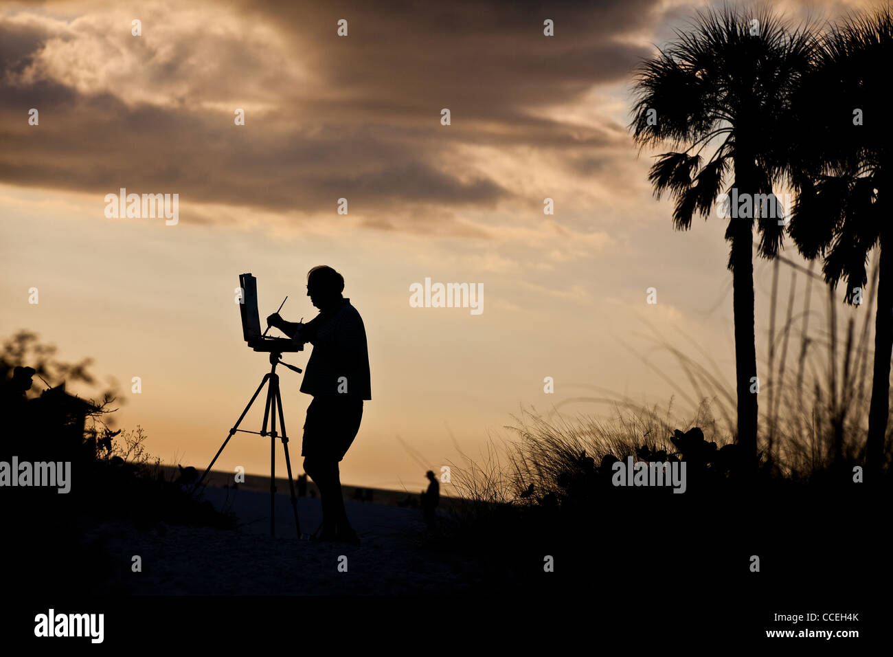 La silhouette d'un artiste peint une scène sur célèbre Siesta Key Beach, Sarasota en Floride Banque D'Images