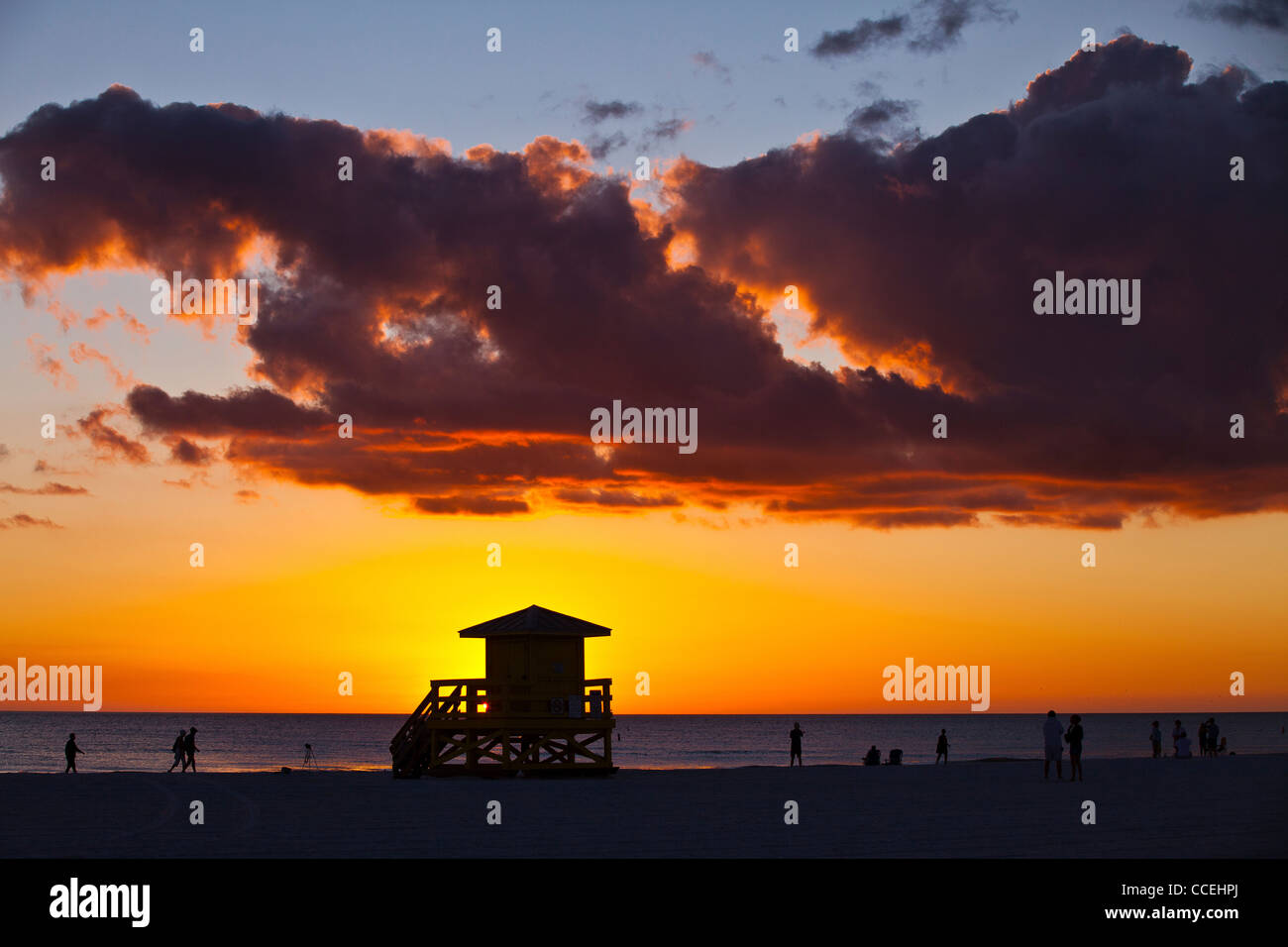 Silhouettes au coucher du soleil sur la station de sauveteur célèbre sable blanc de poudre Siesta Key Beach, Sarasota en Floride Banque D'Images