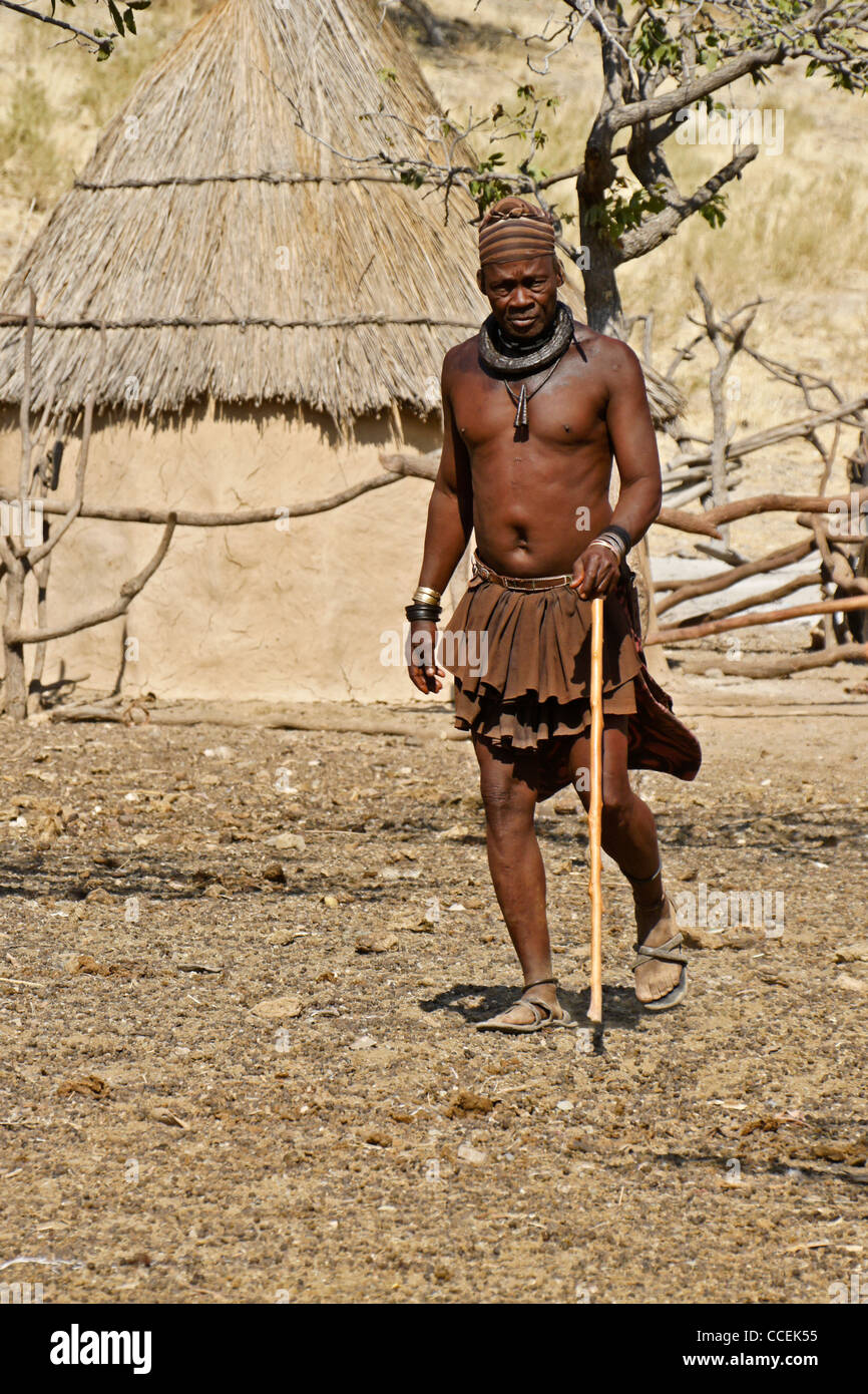 Chef Himba (chef de clan) marche dans village près d'Opuwo, Namibie Banque D'Images