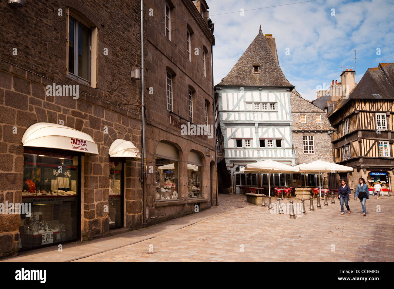 Scène de rue à Dinan, Bretagne France. Deux jeunes femmes à pied à travers le centre-ville, avec ses vieux bâtiments à colombages et c Banque D'Images