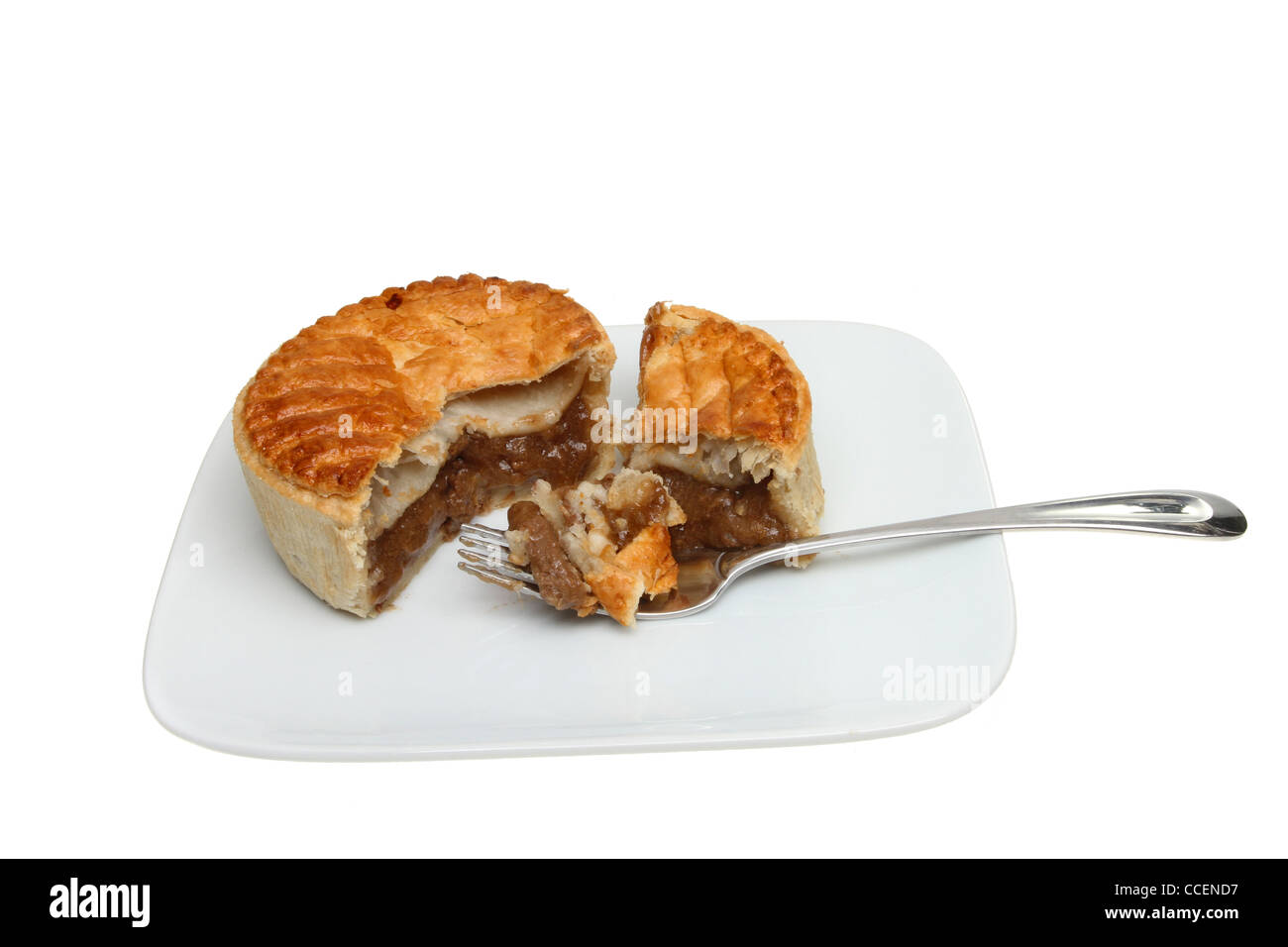 Steak pie à la fourchette sur une assiette blanche contre isolés Banque D'Images