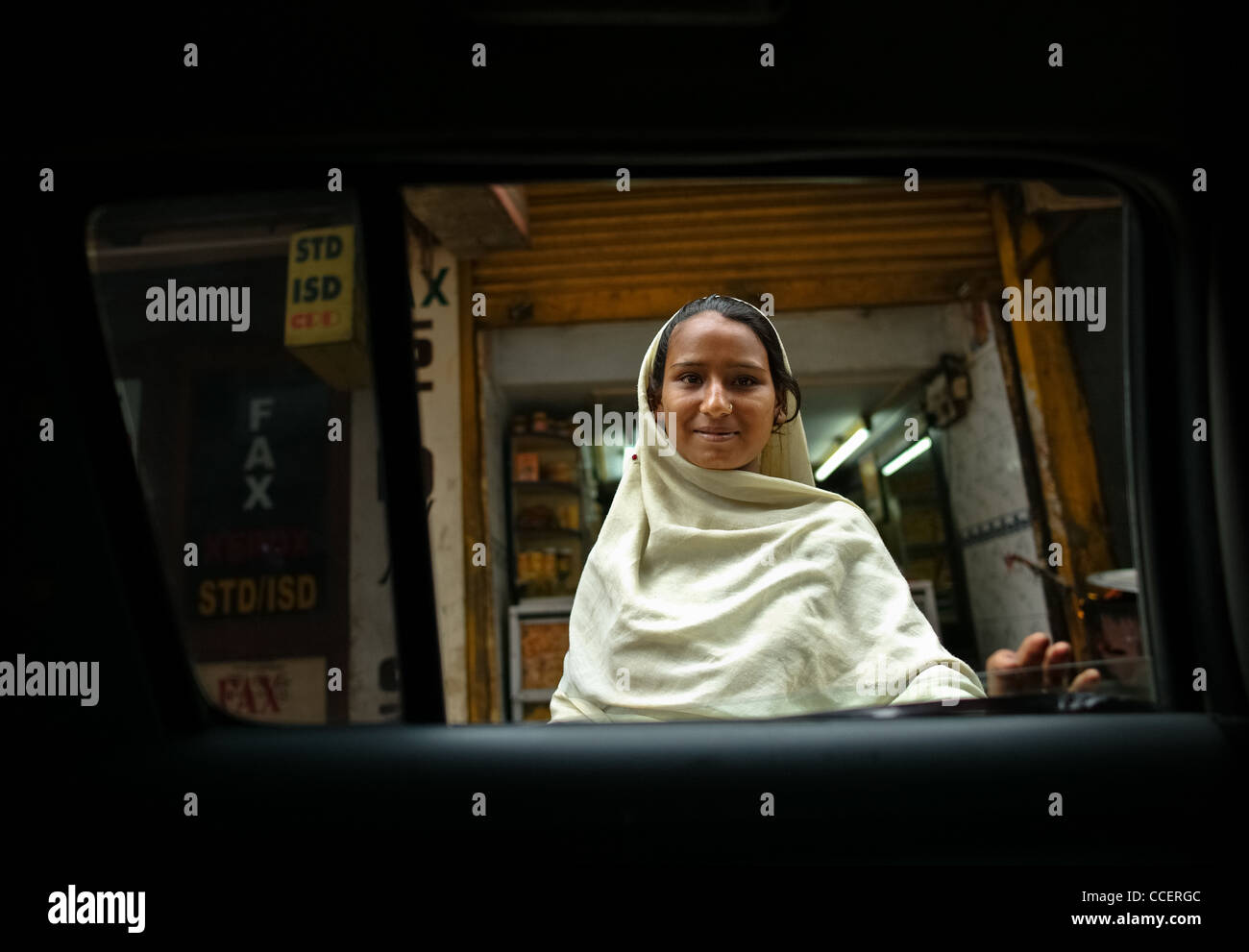 Glisser le Nouveau Delhi. Jeune mendiant a la fenêtre du taxi qui me conduit à l'aéroport , Banque D'Images