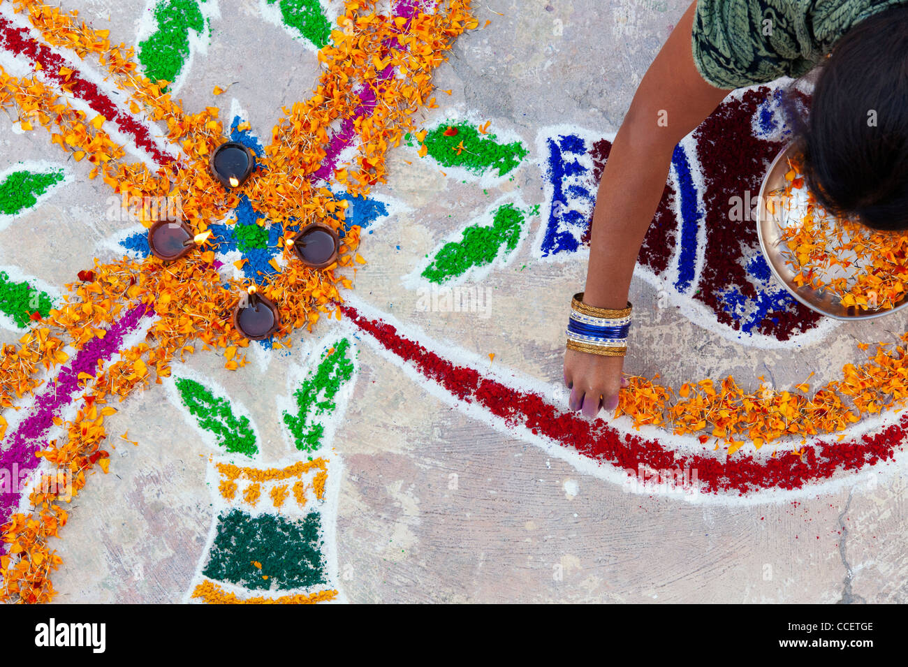 L'Inde jeune femme faisant un rangoli design au festival de Sankranthi. Puttaparthi, Andhra Pradesh, Inde Banque D'Images