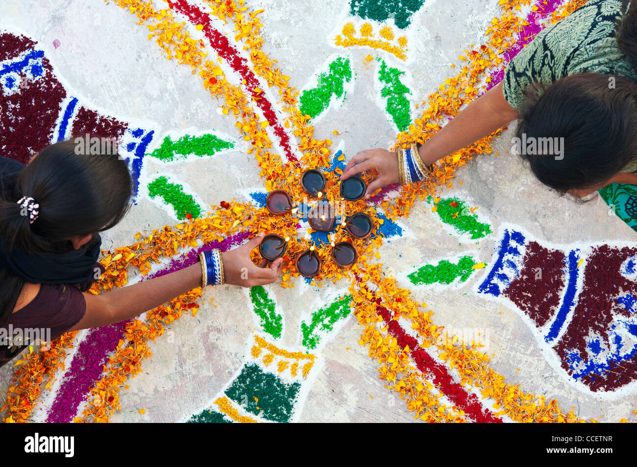 Les sœurs de l'Inde faisant un rangoli design au festival de Sankranthi. Puttaparthi, Andhra Pradesh, Inde Banque D'Images