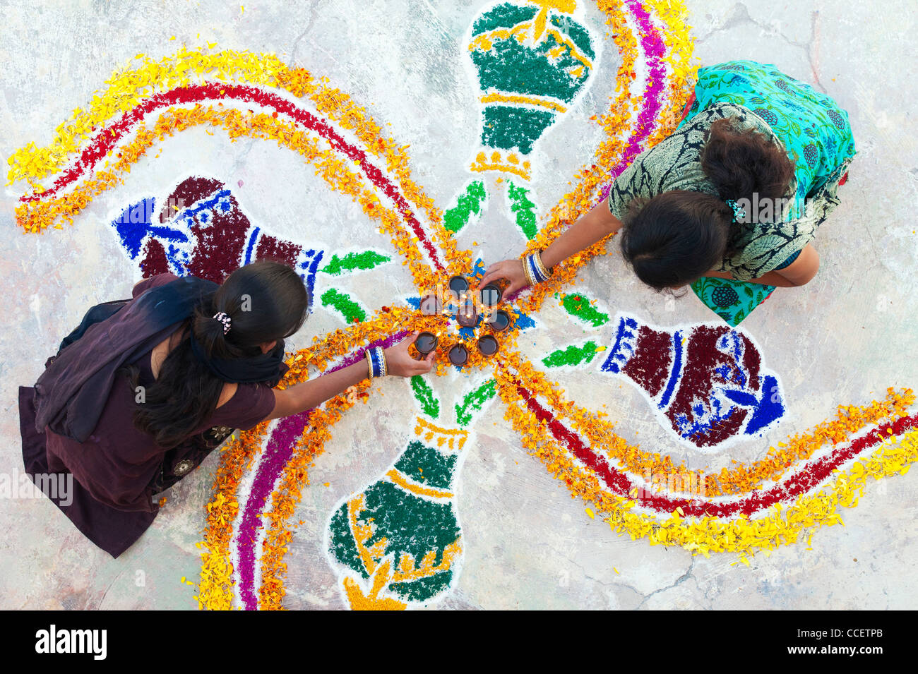 Les sœurs de l'Inde faisant un rangoli design au festival de Sankranthi. Puttaparthi, Andhra Pradesh, Inde Banque D'Images