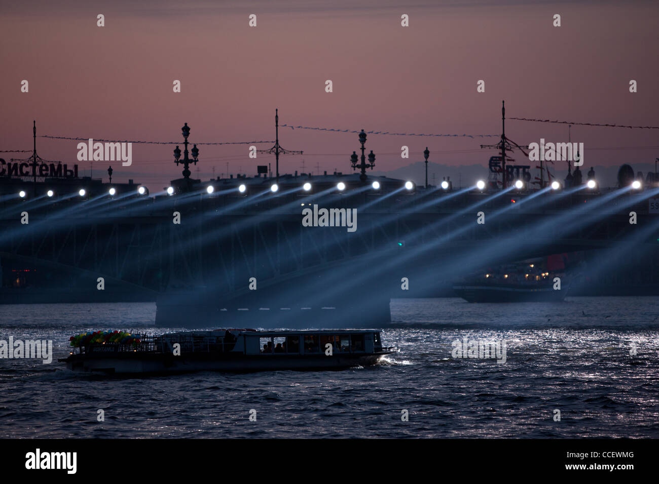 Bateau de croisière approche du pont sur la Neva. Les feux fonctionnent de la surface de l'eau. Nuits blanches à Saint-Pétersbourg. Banque D'Images