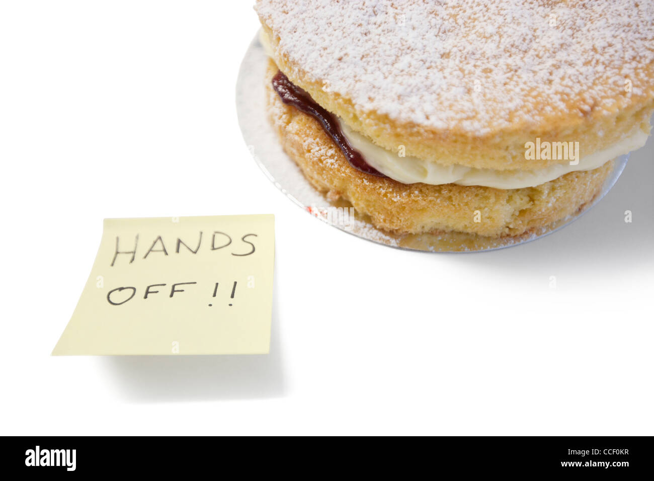 Gâteau éponge avec 'hands off' signe sur papier collant Banque D'Images