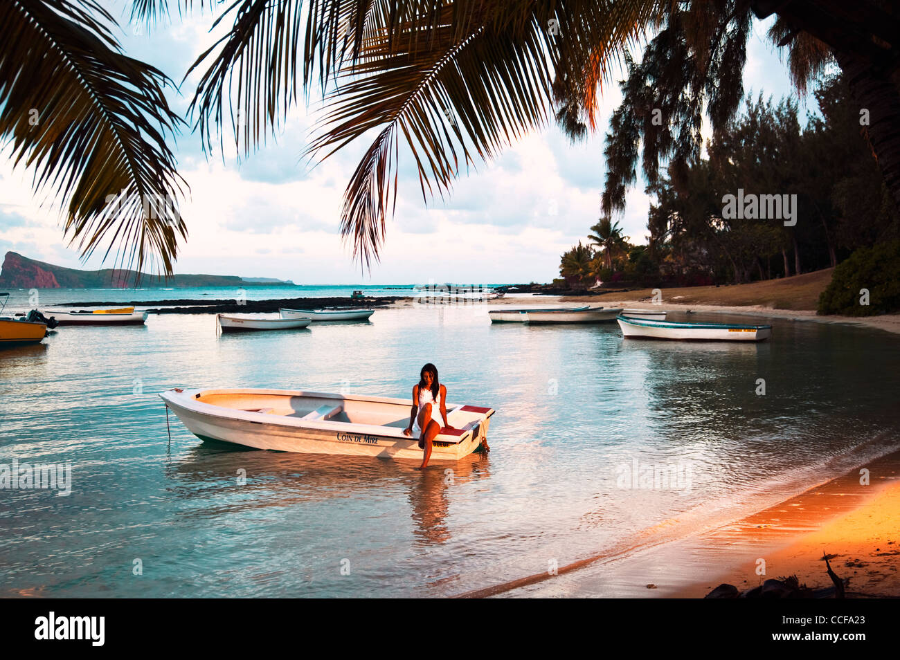 Femme assise sur une pirogue en Coin de Mire dans le Nord de l'île Maurice Banque D'Images