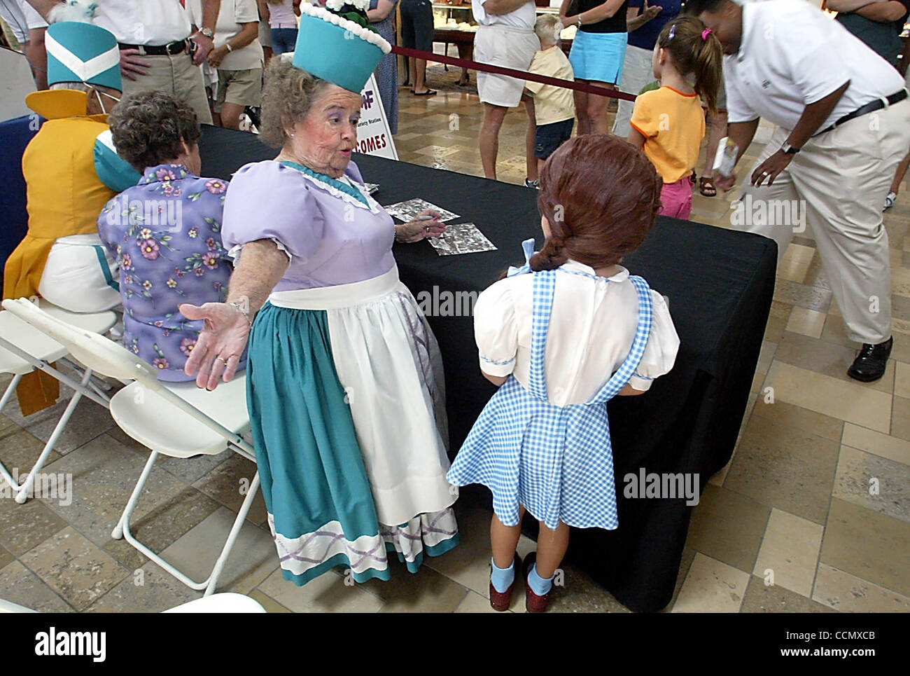 070304 sc a rencontré munchkin08/11 - Boca Raton - Paige Smith (CQ), 5, de Boca Raton, porte son 'Dorothy' - costume complet avec Rubis - de 'The Wizard of Oz' (CQ) comme elle est accueillie par 'munchkin' Margaret Pelligrini (CQ) au centre-ville (CQ) dans la région de Boca Raton Samedi, 3 juillet 2004. À l'extrême gauche est fe Banque D'Images