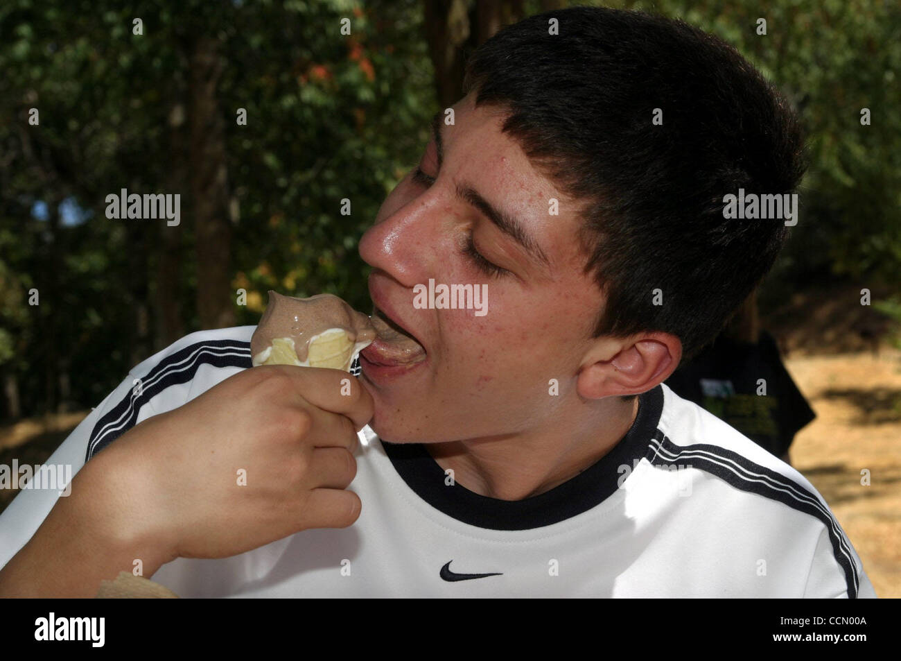 Diego Ortiz (CQ), 14 ans et d'Antioche, des échantillons de crème glacée au chocolat maison faite sur un cornet gaufré à Black Diamond Mines dans la région de Antioch, Californie le samedi 3 juillet, 2004. Les participants ont mis la main thair propres glaces et pris leurs propres cônes alvéolés après naturaliste du parc Sabrina Dussau parlé un Banque D'Images