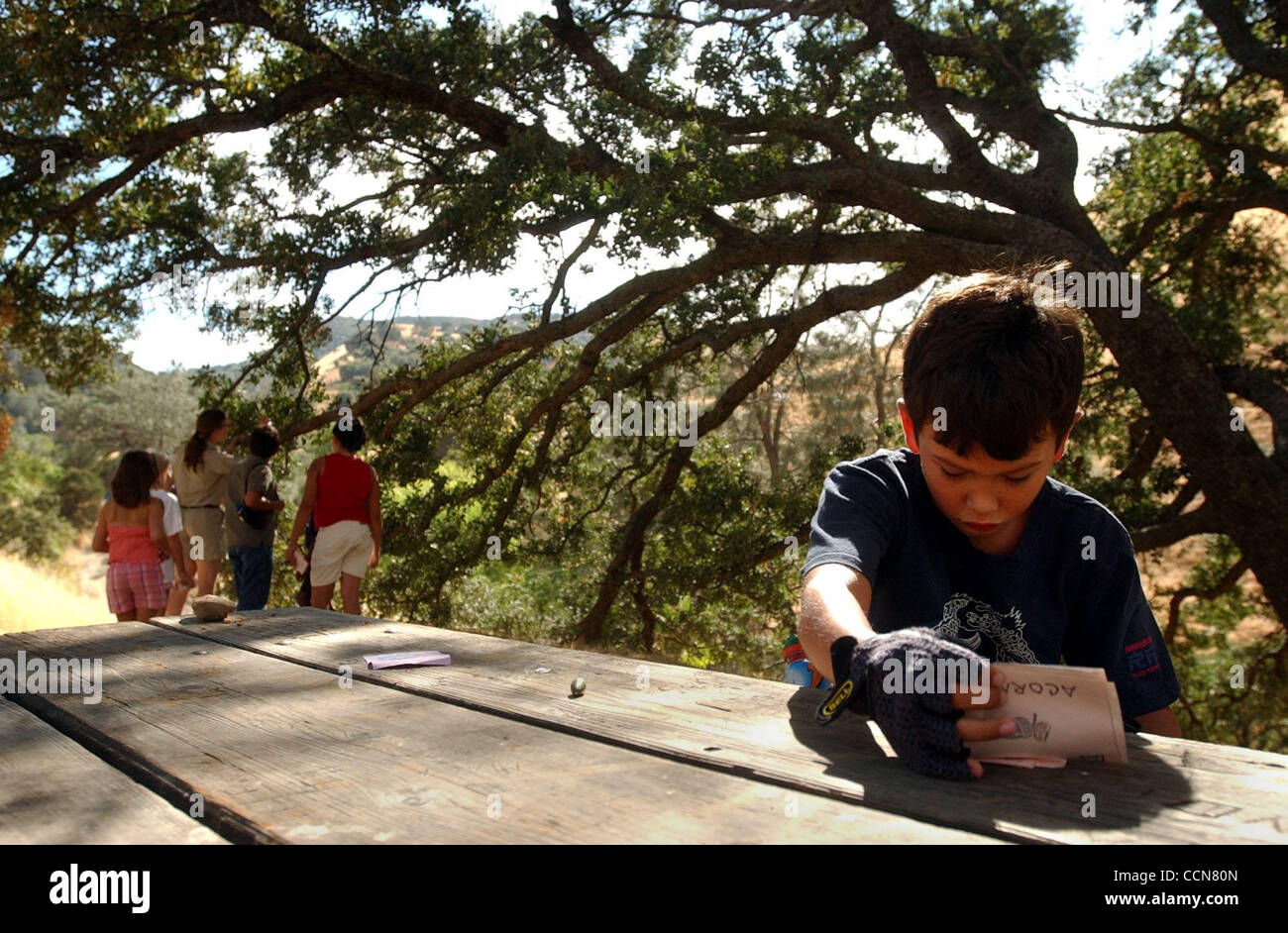 4:24PM--At Black Diamond Mines regional park à Antioche, en Californie d'une semence d'études classe le long d'un sentier, le jeudi, Août 19, 2004, mais Simon Pôrto Novo (accent sur le deuxième e), 8, rassemble des pièces à ses jumelles qui s'est effondré lors d'un arrêt le long de la piste. (Journaux de Contra Costa/Joanna Jhand Banque D'Images
