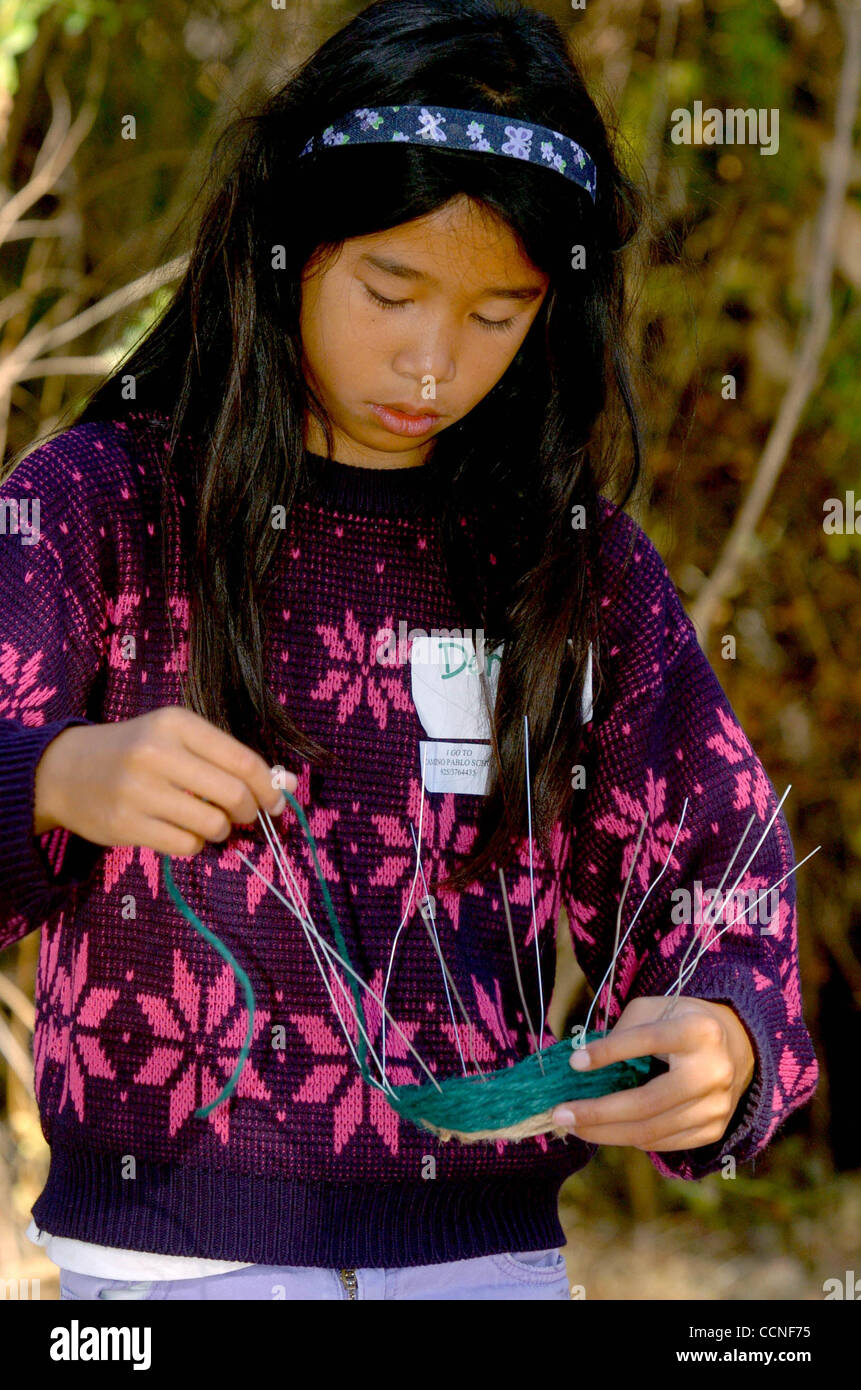 Dana Wong, 8, 3e année à l'école primaire de Rheem Moraga tisse un panier de filés et de fils pendant les jours à l'école. (Contra Costa Times/Bob Larson) Banque D'Images