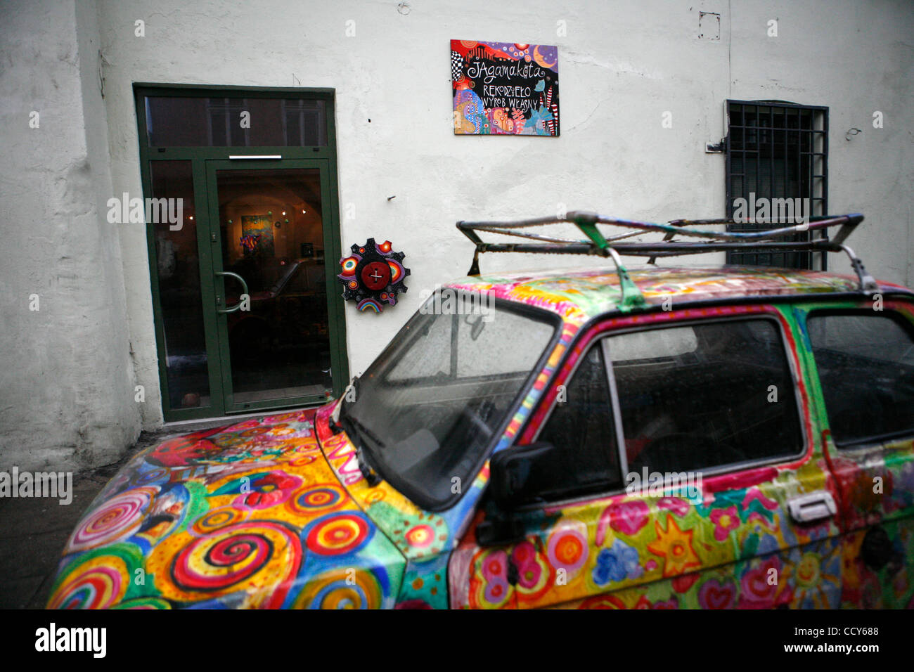 Une galerie d'art à Kazimerz peint avec une voiture de l'ère communiste en face. Avant la chute du communisme en Pologne, l'ancien quartier juif de Cracovie en Kazimerz était délabré et dangereux de visiter de nuit. Aujourd'hui, la région attire l'thousdands de touristes par année provenant de partout dans le monde. L'neighborho Banque D'Images