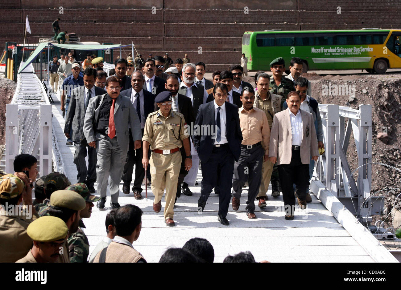 Les membres de la délégation d'affaires à partir de la partie du Cachemire administrée par le Pakistan à pied avec leurs homologues indiens à Kaman Post, 118 km (73 miles) au nord de Srinagar-Summer capitale du Cachemire indien, le 9 octobre 2008. L'Inde et le Pakistan se sont mis d'accord sur des arrangements d'ouvrir une route à la frontière pour le commerce bilatéral en Banque D'Images