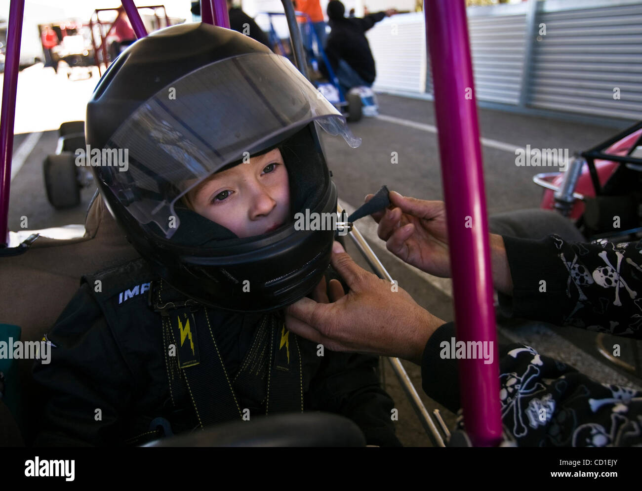 RIO LINDA, CA - le 16 mars : Ryan Gullette ajuster sa fille, Angelika Gullette, 6, casque comme elle se prépare à la race de son trimestre midget racer au Roy Hayer Memoiral Speedway, une piste de course midget trimestre a été prévue pour la clôture par comté à Rio Linda, Californie le 16 mars 2008. Sacra Banque D'Images