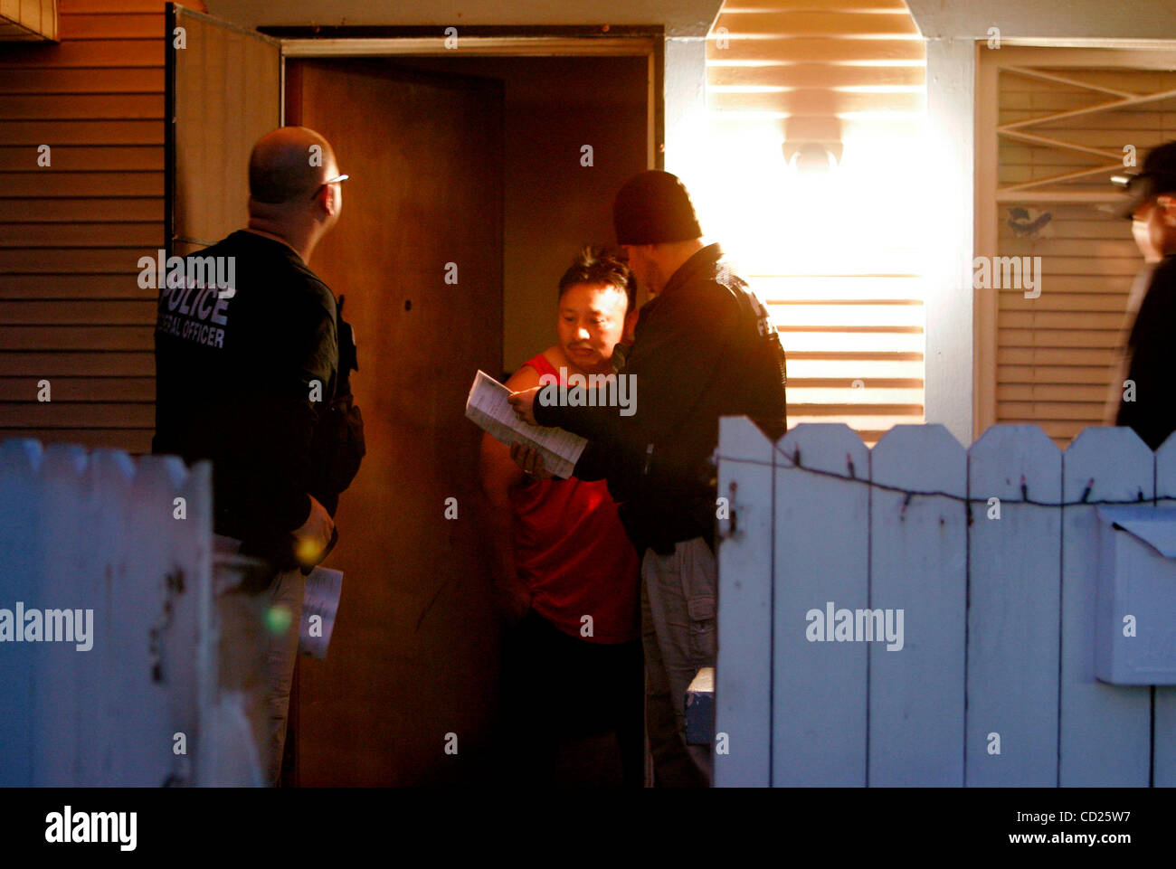 Novembre 21, 2008, Escondido, California, USA au lever du soleil, les agents d'expulsion de la glace s'exprimer d'un homme à une maison sur le bloc 600 de S. Escondido Blvd. Ils étaient là à la Cruz Manuel Estaban, 28, du Guatemala, qui a ignoré un ordre de déportation. L'homme dans l'embrasure de la porte avait une carte verte et w Banque D'Images