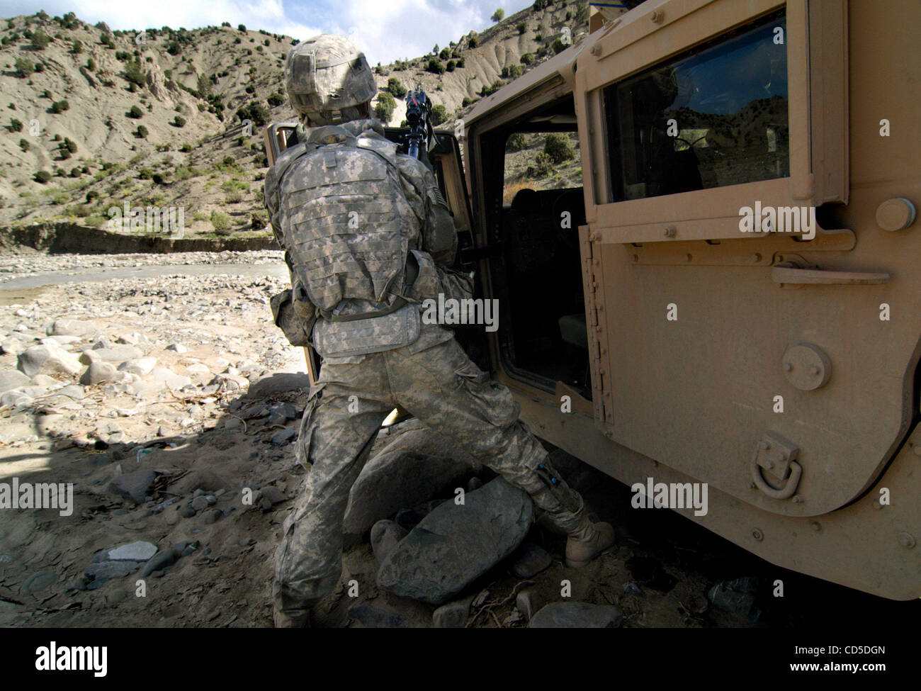 Apr 24, 2008 - La province de Paktya, Afghanistan - Un soldat de la Compagnie Charlie, 1-61, 4e de cavalerie BCT, 101ème Abn., boucliers lui-même derrière son Humvee, couvrant avec son M-4 carbine ses coéquipiers qu'ils escaladent la crête hors de vue dans la poursuite des personnes soupçonnées d'ACM (milice anti-coalition afghane dans l'Est) Banque D'Images