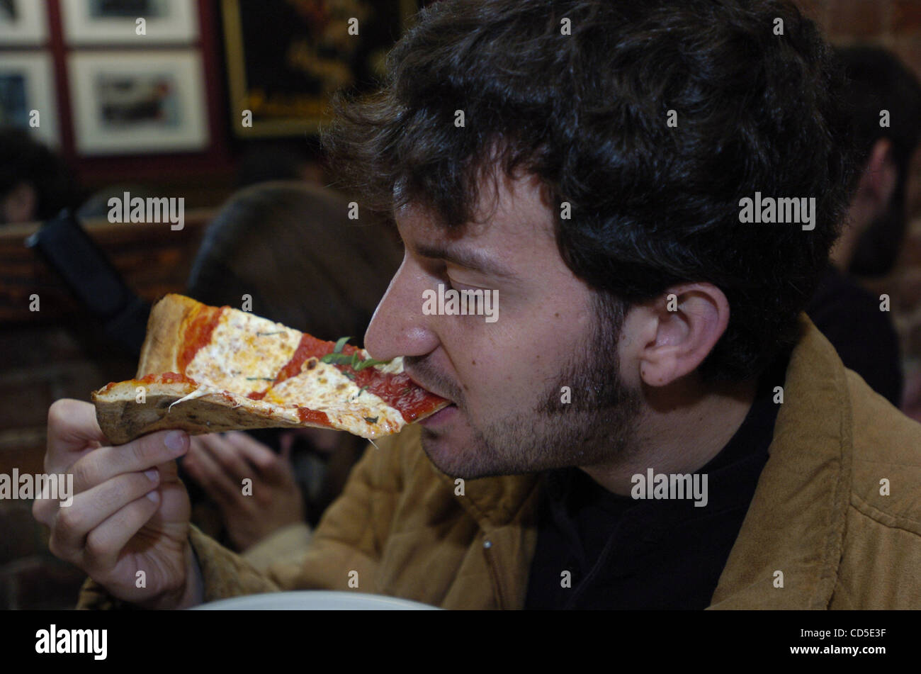 Jon Anzalone, 25 ans, de Brooklyn bénéficie d'une tranche de Lombardi's Pizzeria. Scott Wiener, 26, de Hoboken, N.J. a commencé Scott's Pizza Tours en bus où les gens sont pris à New York's best pizzerias. Chaque visite commence au Lombardi's Pizzeria dans la petite Italie et est de 4 1/2 heures de long et comprend des coupes au f Banque D'Images