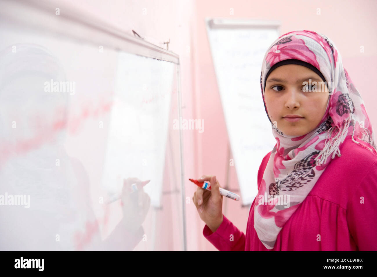 12 juillet 2010 - Amman, Jordanie - le 12 juillet 2010, Amman, Jordanie - une fille termine une leçon sur le tableau pendant un cours de mathématiques dans le cadre d'une organisation non gouvernementale (ONG) Projet visant à maintenir les enfants vulnérables, dont un grand nombre de réfugiés, à l'école. En tout, 1 200 jeunes vulnérables sont impliqués dans Banque D'Images