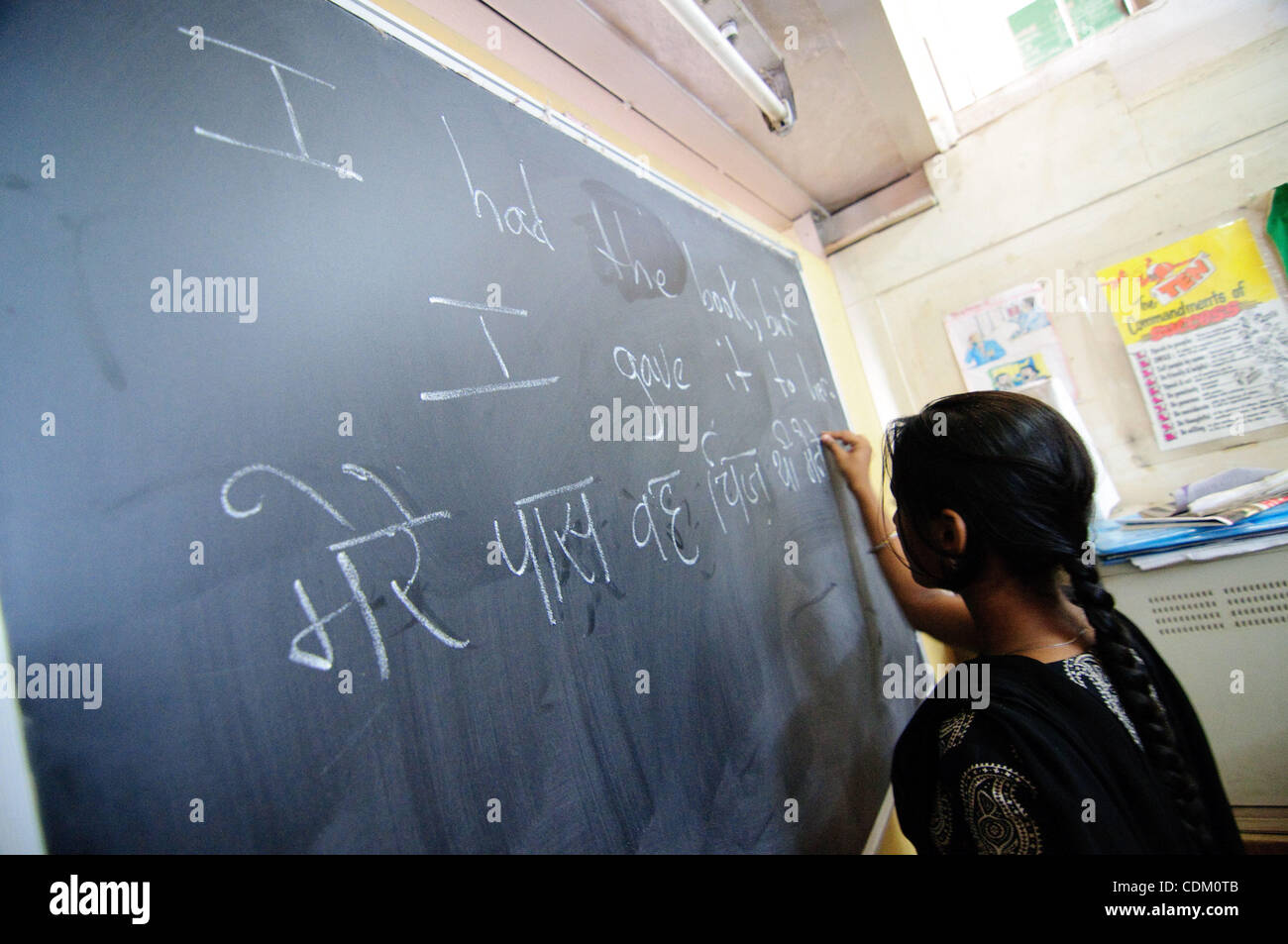 Un élève écrit au conseil d'administration d'une école à but non lucratif à Bandra East pendant un cours d'anglais. L'école assure la formation de underpiviledged enfants d'obtenir de bons emplois. Banque D'Images