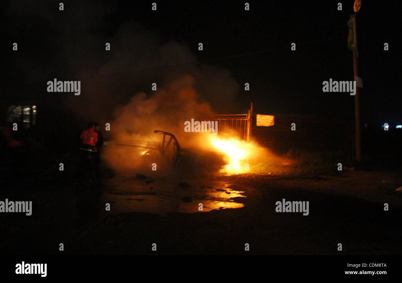 Membres de la défense civile, essayer d'arrêter le feu dans une voiture après une frappe aérienne israélienne dans la région de Deir Al-Balah dans le centre de la bande de Gaza début avril 2, 2011. Des avions israéliens ont tué trois Palestiniens armés dans le sud de la bande de Gaza tôt le samedi , les autorités médicales et de l'armée israélienne a dit.. Photo par Ashraf Banque D'Images