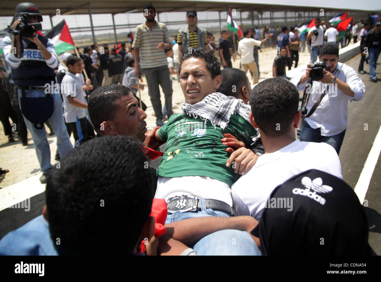 Les Palestiniens portent un manifestant blessé après que les troupes israéliennes ont ouvert le feu lors d'une marche en direction de la d'Erez dans le nord de la bande de Gaza, le 15 mai 2011, que les gens se sont réunis pour marquer le "nakbah' ou 'catastrophe' anniversaire de la création d'Israël en 1948, à la suite de laquelle Banque D'Images