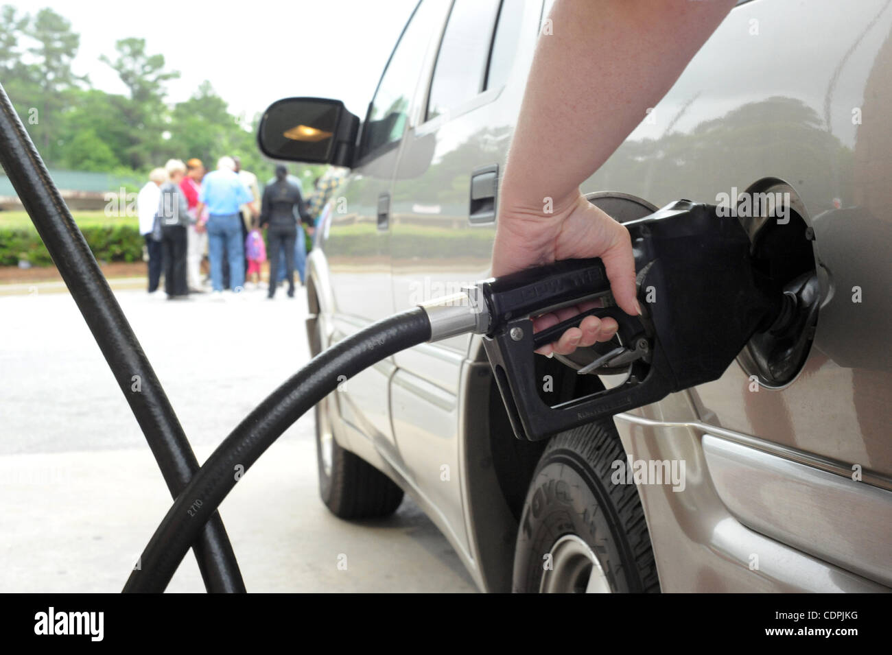 Avril 16, 2011 - Dublin, Ohio, États-Unis - Un client se remplit son véhicule en tant que personnes tenir la main tout en participant à une veillée de prière pour la baisse des prix du carburant à côté d'une station essence de supermarché Kroger à Dublin, Georgia USA le 16 avril 2011. C'est la troisième fois que le pasteur Marshall Mabry du phare de Banque D'Images