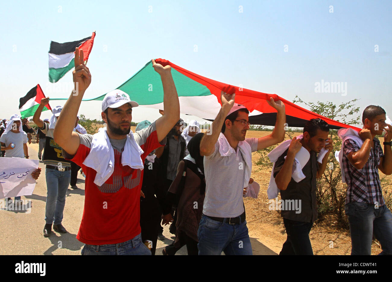 Des manifestants palestiniens vague drapeaux nationaux lors d'une manifestation le 30 juillet 2011 à la périphérie de la ville de Gaza contre la zone militaire Israël a créé sur le territoire palestinien, à l'est de la ville, comme un tampon entre les zones frontalières et à la gestion du Hamas de Gaza. Israël a créé la zone de 'sécurité' durin Banque D'Images