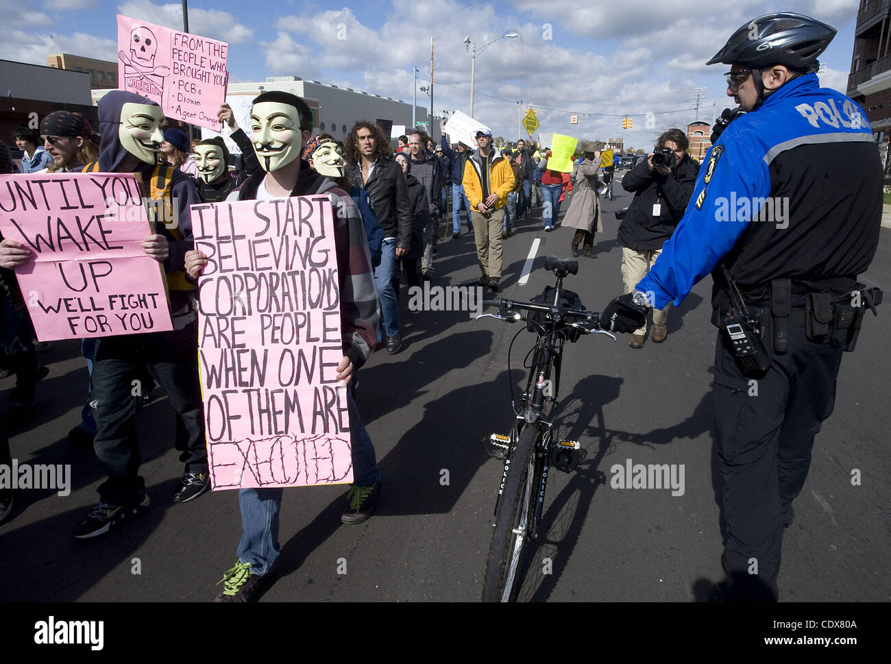 15 octobre 2011 - Lansing, Michigan, États-Unis - Manifestants mars comme un agent de police se tient près de Lansing pendant un événement à occuper Lansing Lansing, MI le Oct 15, 2011. Les manifestants se sont réunis samedi à la capitale de l'état, puis ont marché une boucle à travers la ville. (Crédit Image : © Mark Bialek/ZUMAPRESS.com) Banque D'Images