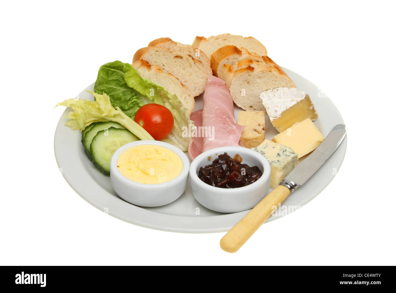 Plowmans le déjeuner, du pain, du fromage et du jambon et de la salade avec du beurre et cornichons sur une plaque avec un couteau isolés contre white Banque D'Images