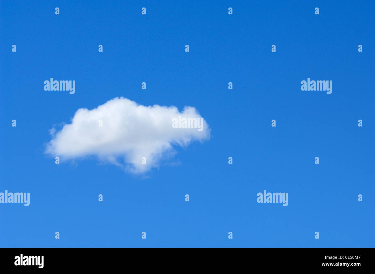Un seul nuage tandis que contre un ciel bleu clair avec copyspace. Banque D'Images