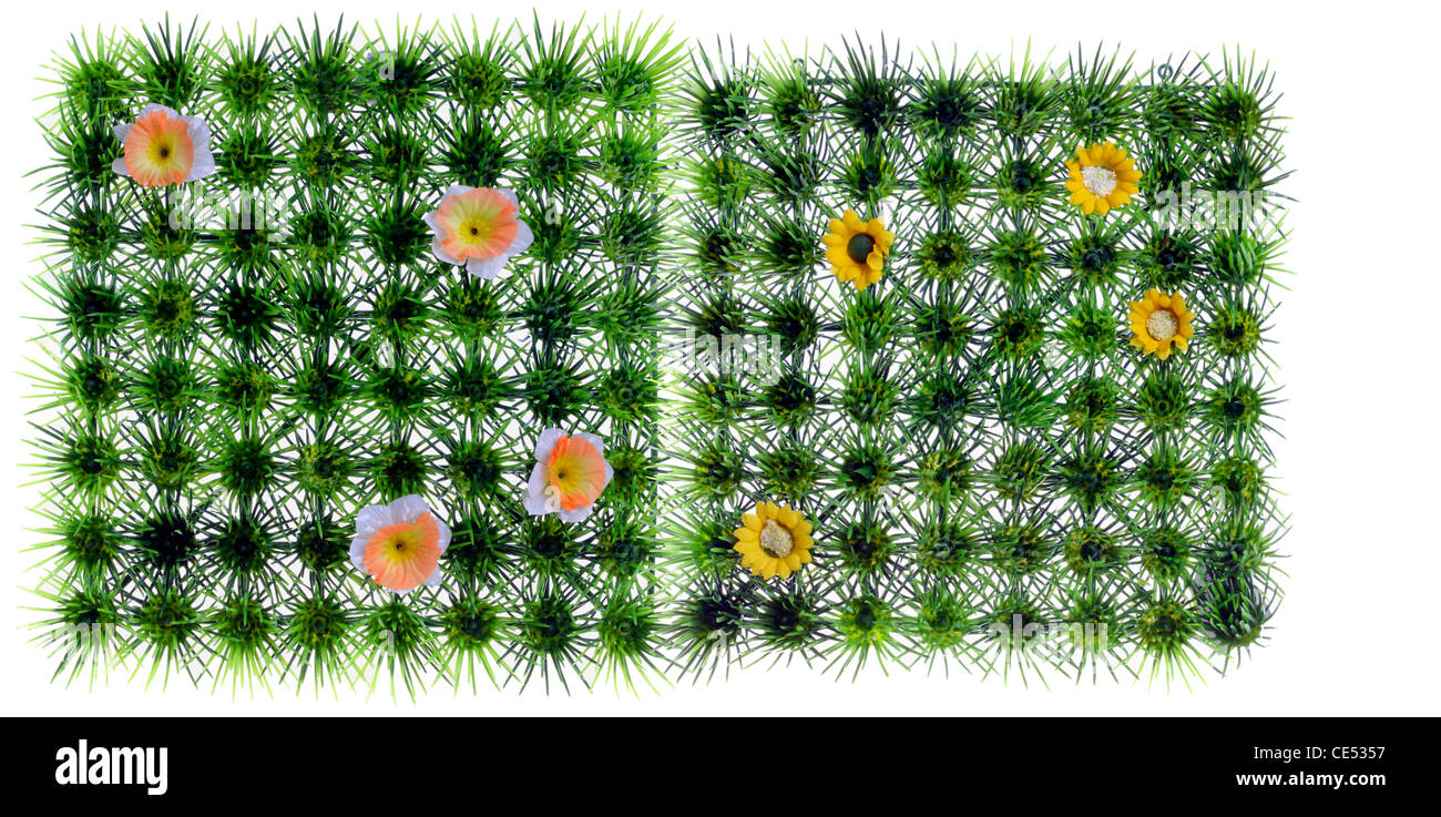 Gazon artificiel, quadratique, prairie, avec des fleurs en plastique jaune. La décoration. Banque D'Images
