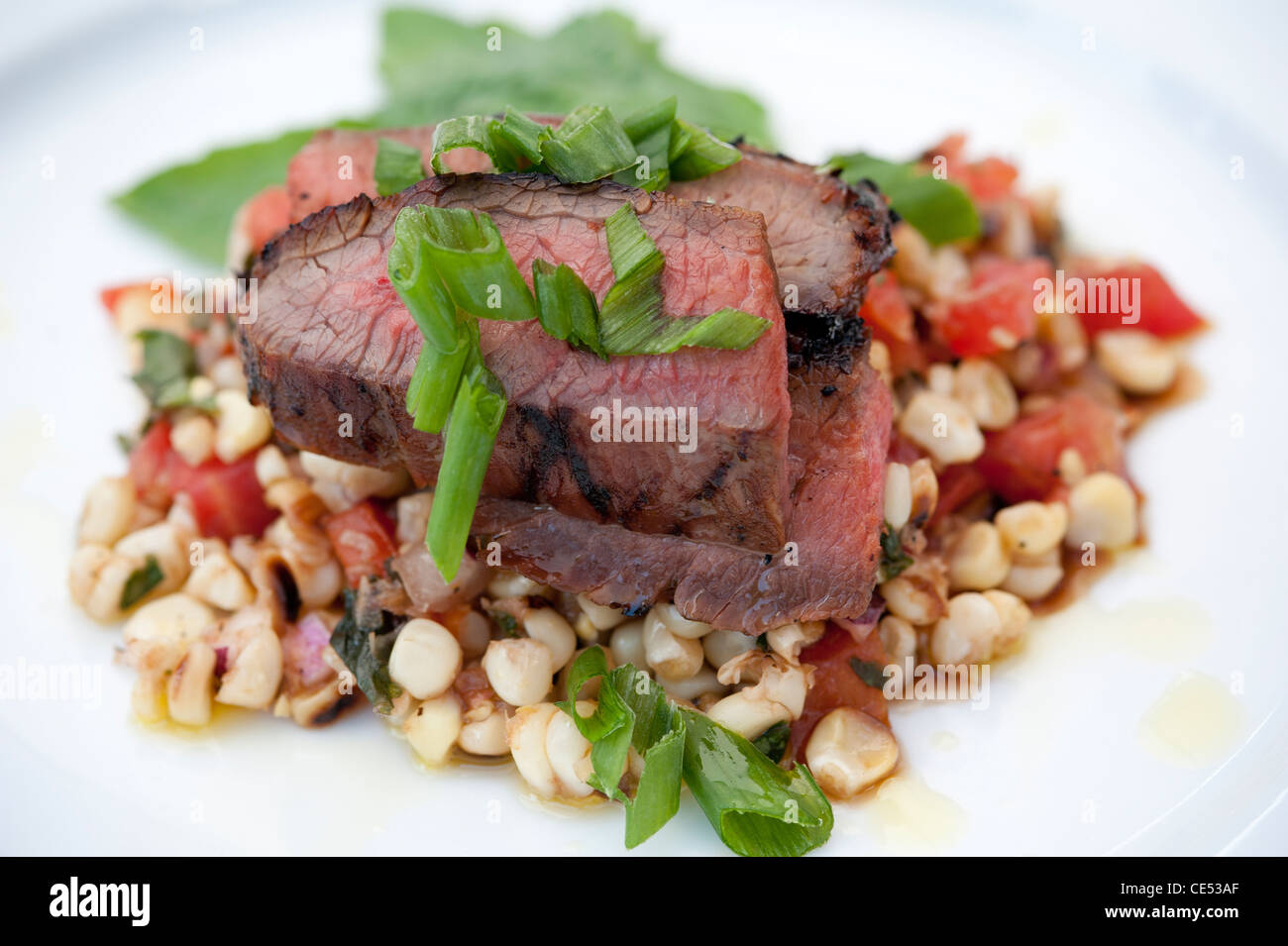 Plat gastronomique de tranches de rôti de boeuf sur salade de maïs Banque D'Images