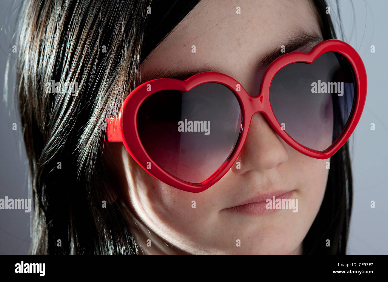 Jeune femme fille portant des lunettes de soleil en forme de coeur Banque D'Images
