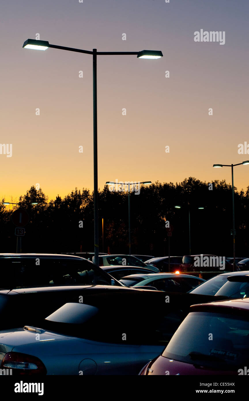 Les véhicules garés dans un parking très occupé au crépuscule en Angleterre. Banque D'Images