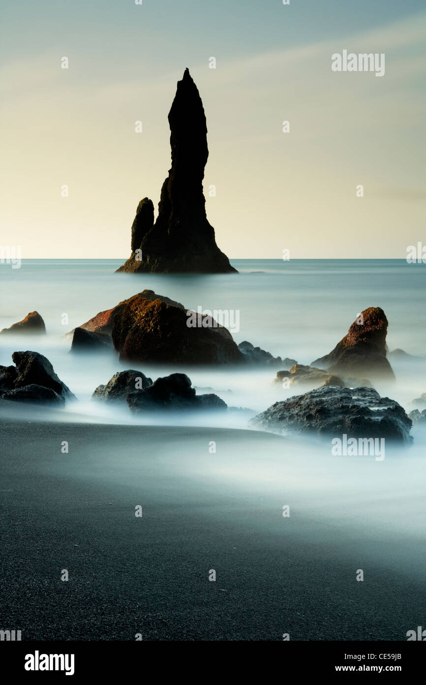 En ondes lave volcanique noire autour de piles de la mer sur la côte d'Islande Vik Banque D'Images