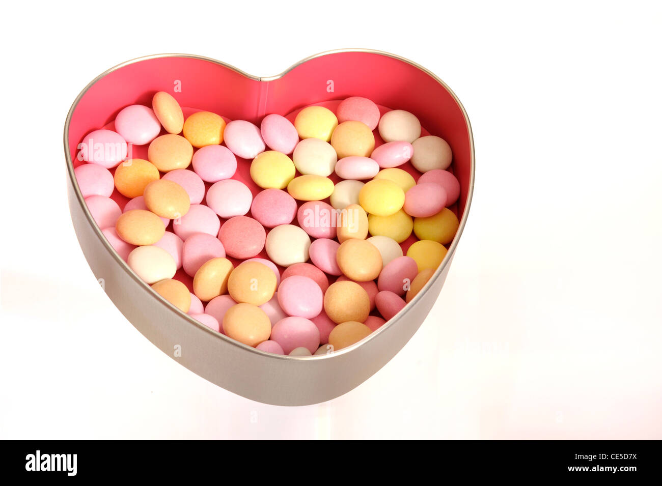 Bonbons dans une boîte en forme de coeur en argent avec rose à l'intérieur Banque D'Images