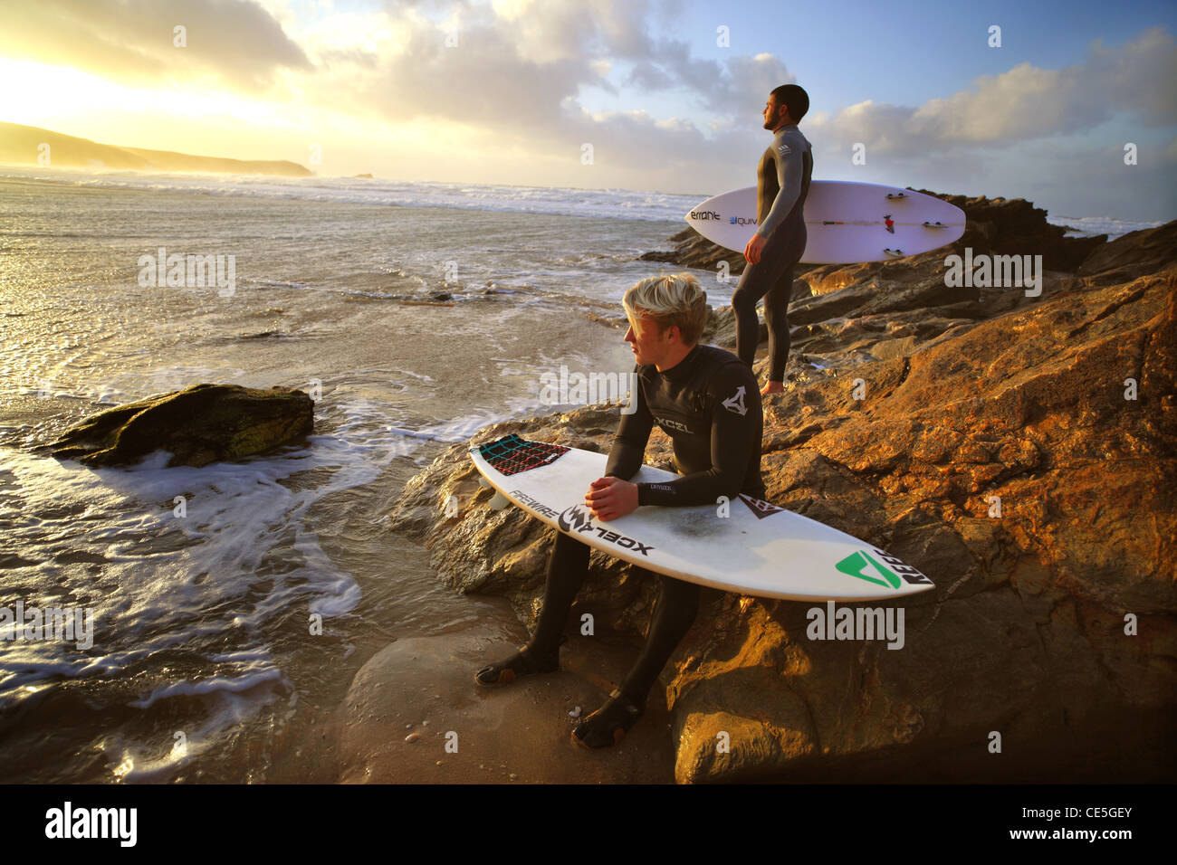 Regarder les surfeurs l'hiver coucher de soleil sur la plage de Fistral, Newquay, Cornwall, UK. Banque D'Images