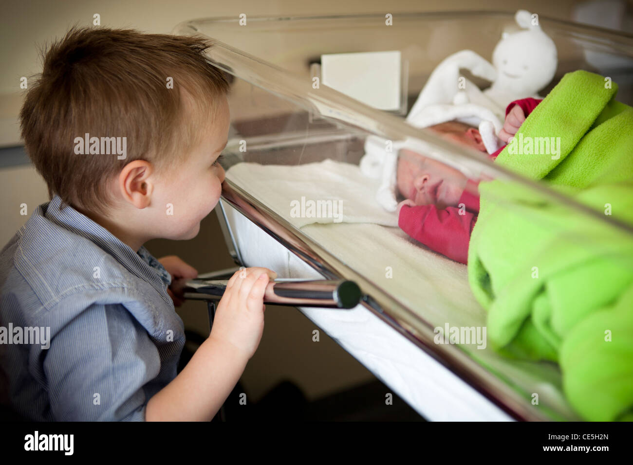 Un enfant garçon regarde ses nouveau-sœur à la maternité. Banque D'Images