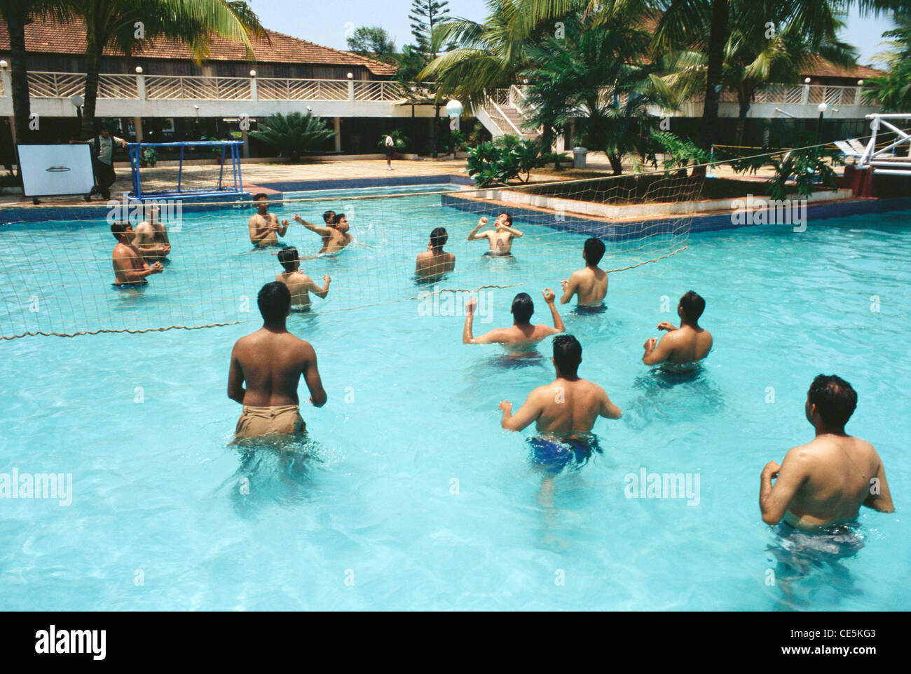 Les hommes jouant du volley-ball en piscine ; Goa Inde ; Banque D'Images