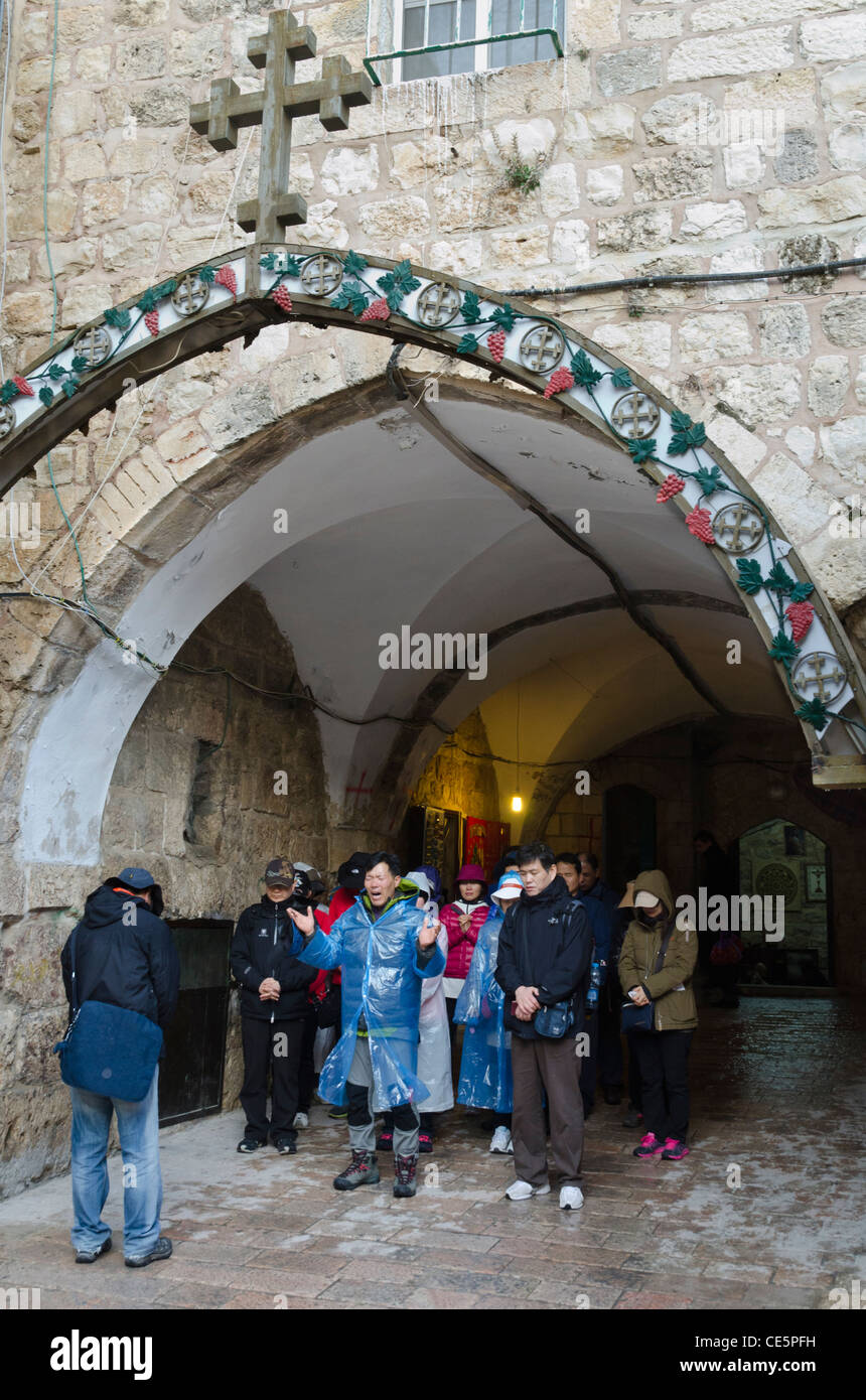 Pèlerins d'Asie prière à IX de la station du chemin de croix. Jérusalem Vieille Ville. Israël Banque D'Images