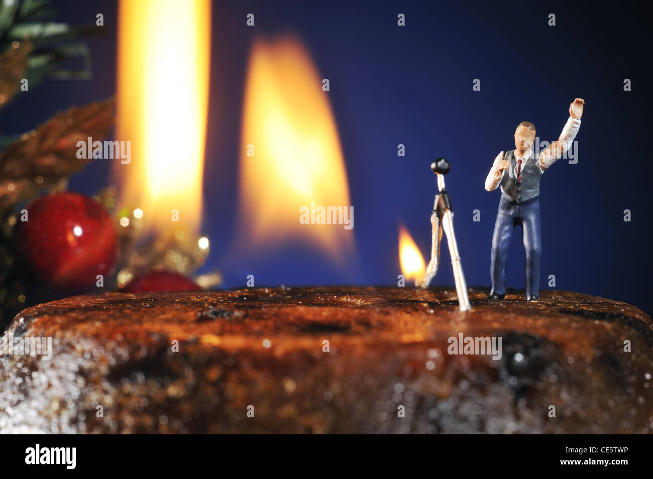 Un photographe modèle derrière le feu sur un pudding de Noël. Banque D'Images