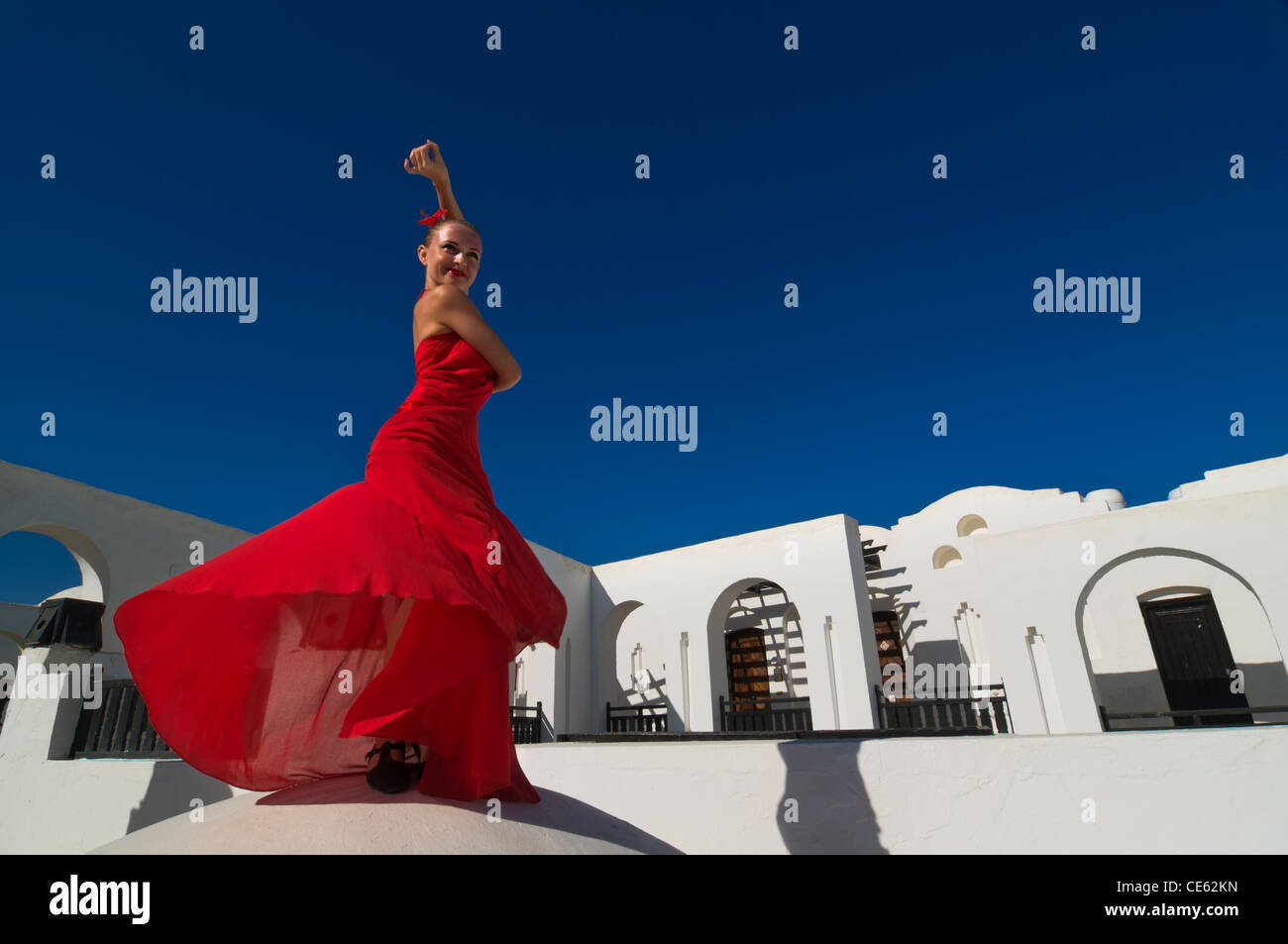 Danseuse de flamenco traditionnel attrayant portant robe rouge avec une fleur dans ses cheveux Banque D'Images